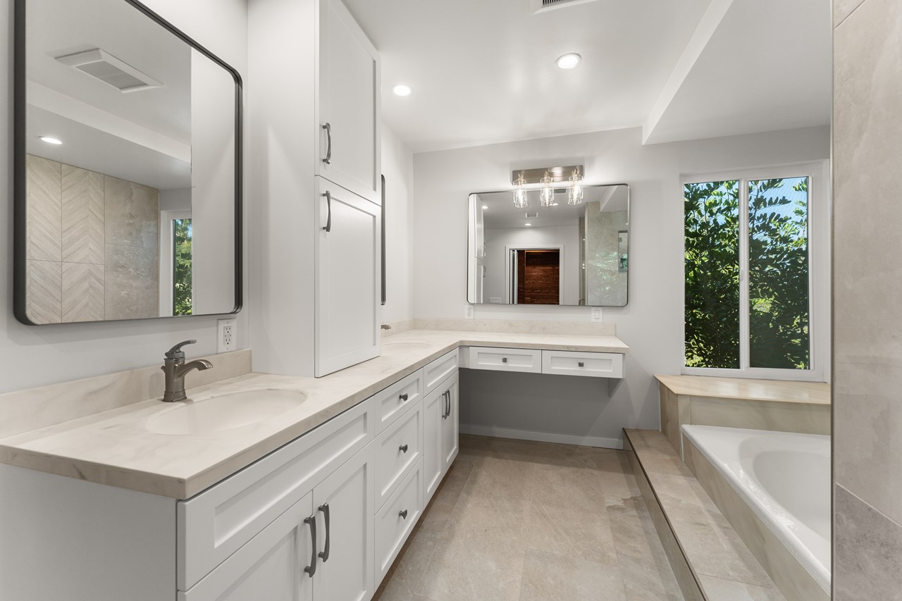 the primary suite features two sinks, a vanity, and an over abundance of storage.