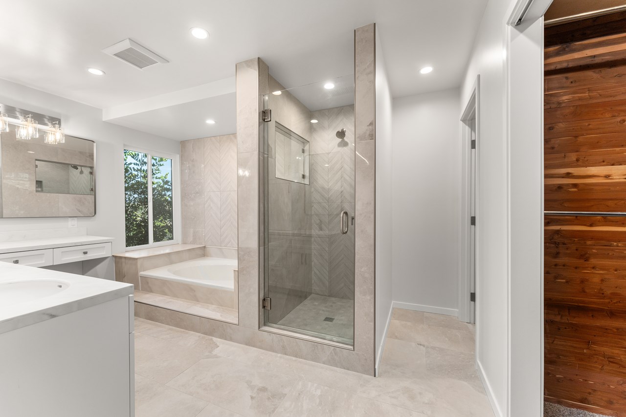 the primary suite features an oversized tub, walk in shower, cedar lined walk-in closet, and a private hidden bathroom.