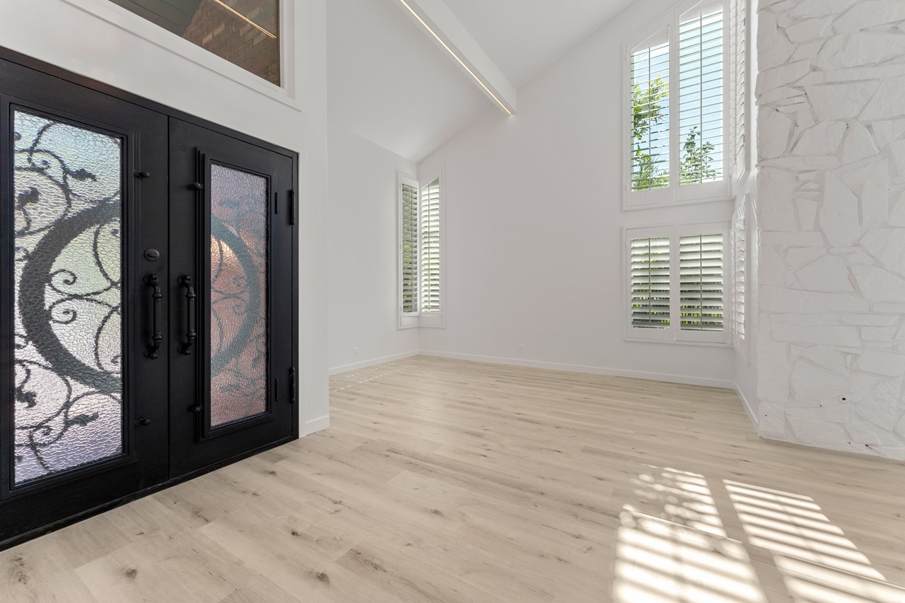 the entry features an iron double front door with opaque opening windows on each side.