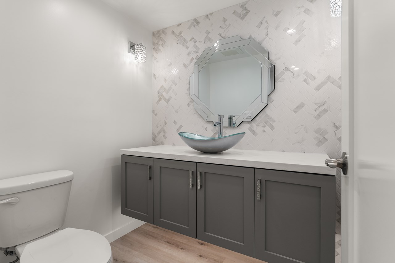 the downstairs bathroom features a vessel sink and beautiful under cabinet lightening.